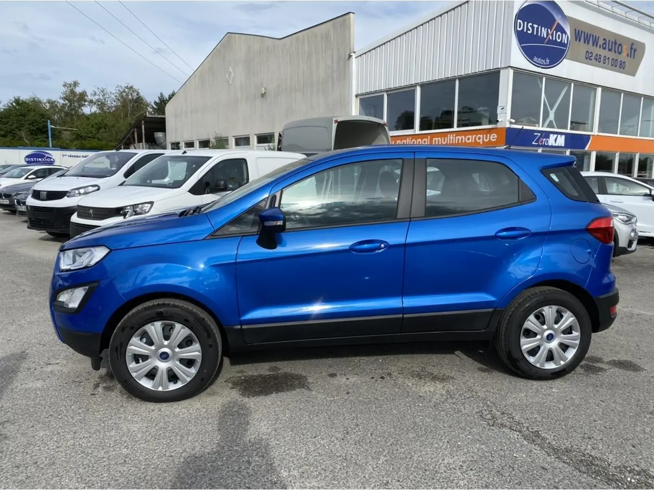 Ford EcoSport 2022 bleu Island vu de profil côté gauche, avec jantes acier et poignées de porte assorties.