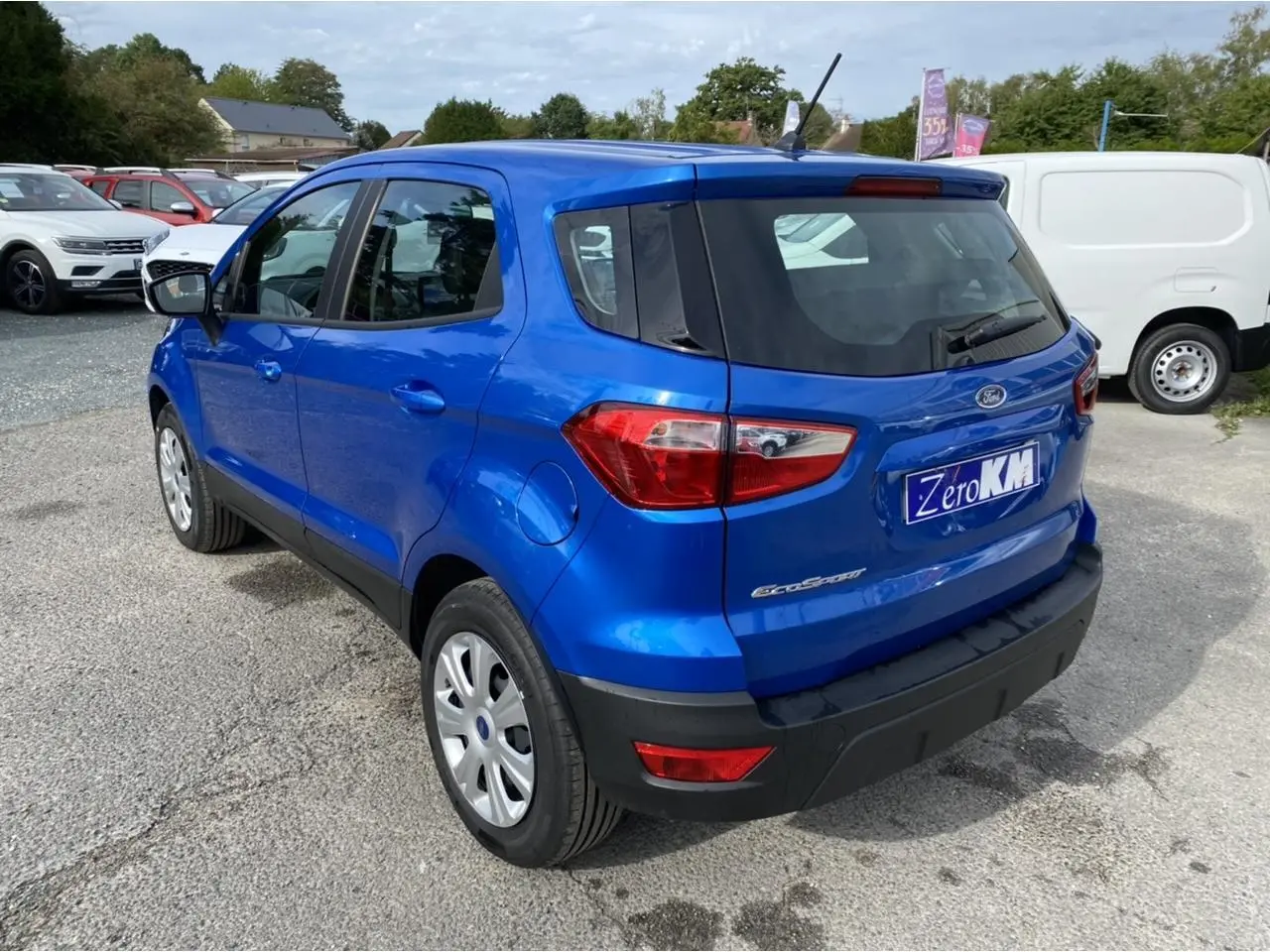 Vue 3/4 arrière droite d'un Ford EcoSport bleu Island métallisé, avec feux arrière et pare-chocs noirs visibles.