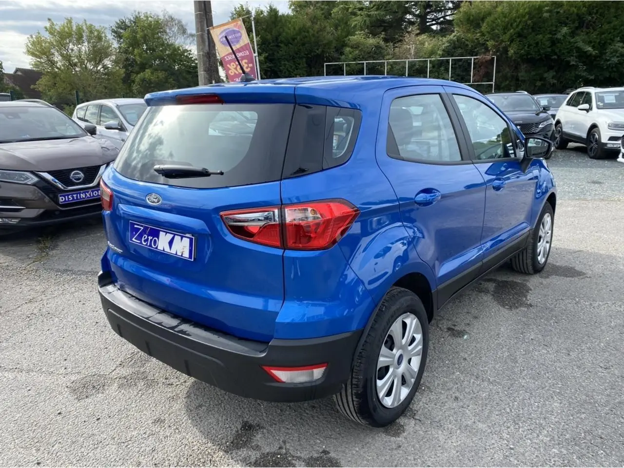Vue 3/4 arrière droite d'un Ford EcoSport bleu Island 2022 avec feux arrière et pare-chocs noirs visibles.