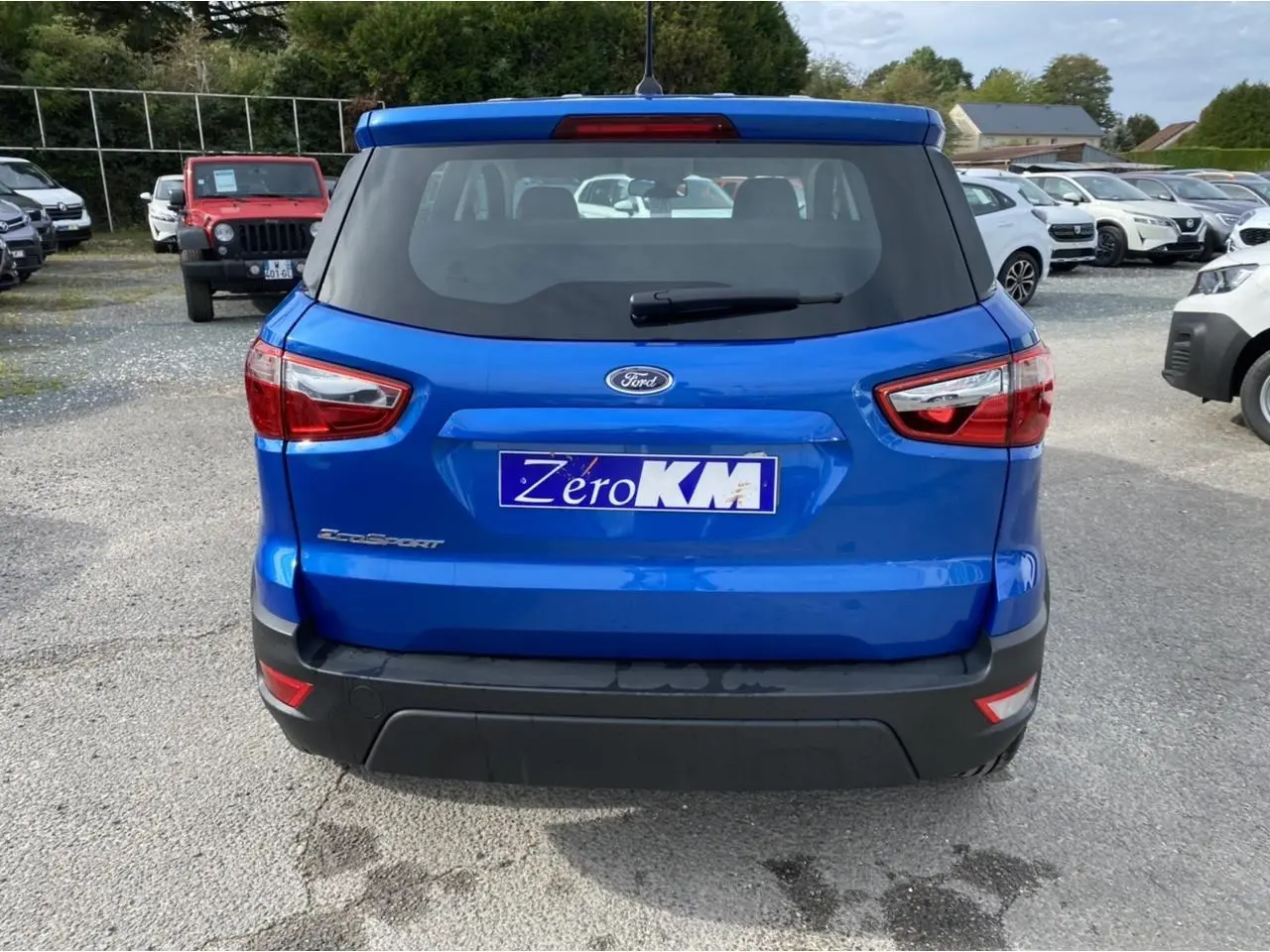 Vue arrière d’un Ford EcoSport bleu Island 2022 avec feux arrière et plaque d’immatriculation Zéro KM visible.