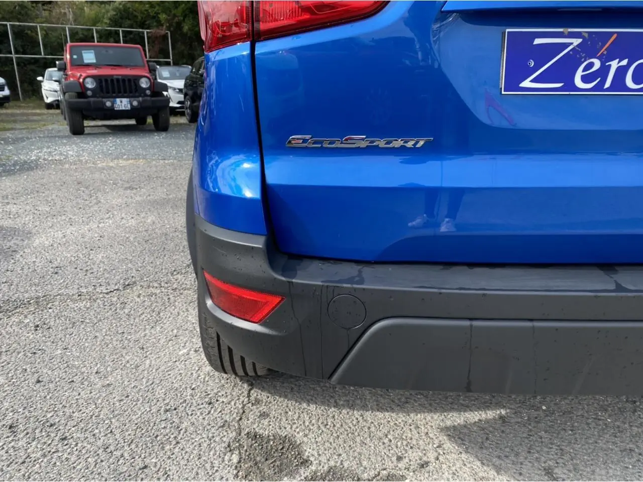 Vue rapprochée de l’arrière droit d’un Ford EcoSport bleu Island avec logo EcoSport et feu antibrouillard.