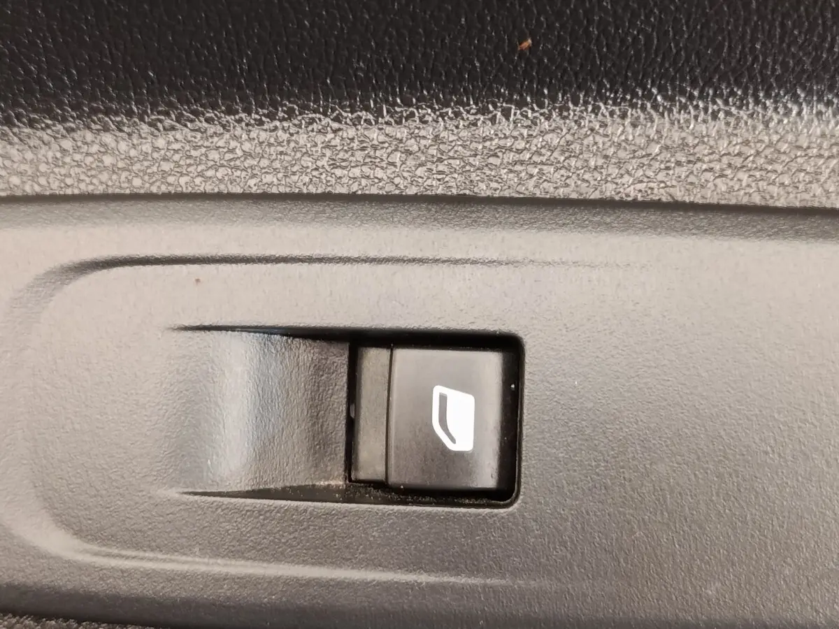 Gros plan sur le bouton de commande de vitre électrique dans l'habitacle d'un Peugeot Partner blanc 2022.