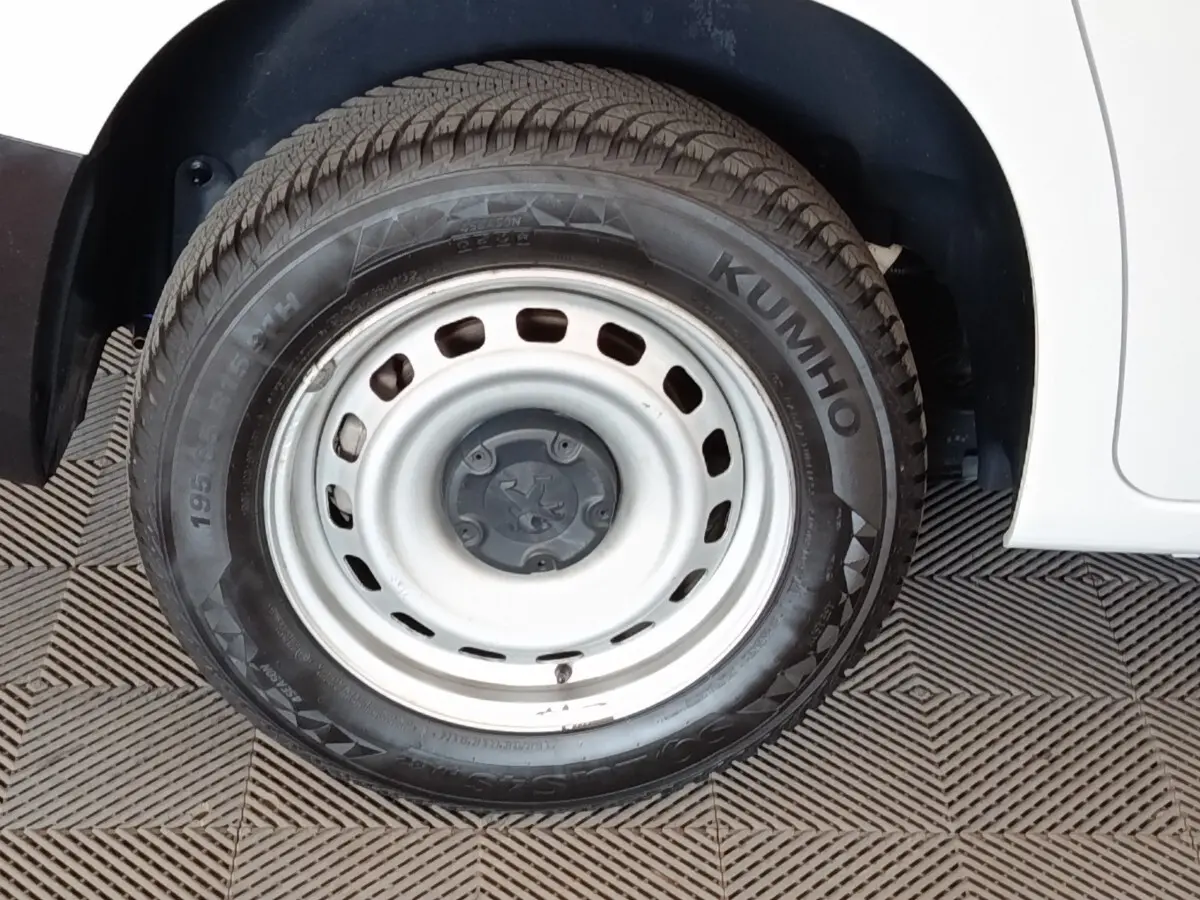 Gros plan sur la roue avant droite acier blanche d’un Peugeot Partner blanc 2022, avec pneu Kumho visible.