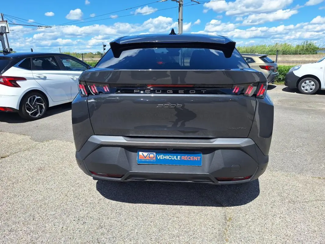 Vue arrière d’un Peugeot 3008 Hybrid gris foncé 2025 avec feux arrière à griffes et jantes alliage visibles.