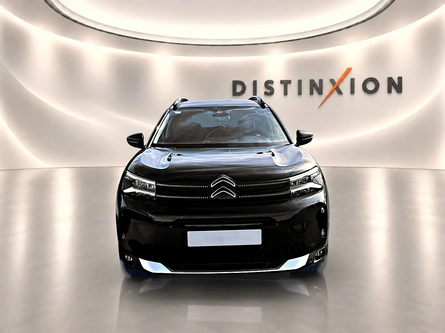 Vue avant d'un Citroën C5 Aircross noir 2025 dans un showroom avec éclairage moderne et logo Distinxion.