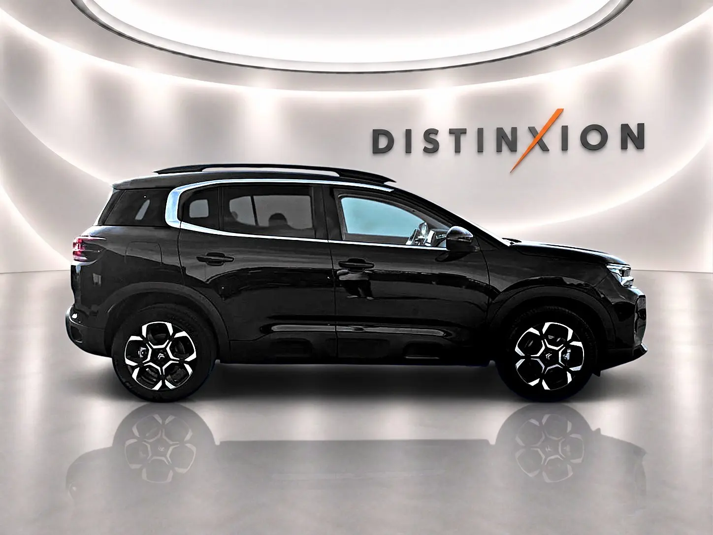 Profil droit noir brillant du Citroën C5 Aircross 2025 avec jantes alu et barres de toit visibles en studio.