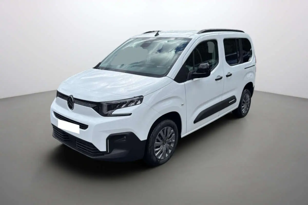Citroën Berlingo Kaolin white en 3/4 avant droit, avec barres de toit et vitres arrière surteintées.