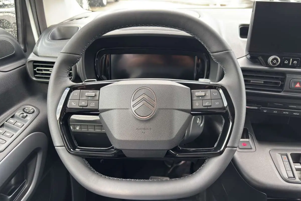 Vue rapprochée du volant multifonctions en cuir du Citroën Berlingo 2026 avec tableau de bord et écran tactile.