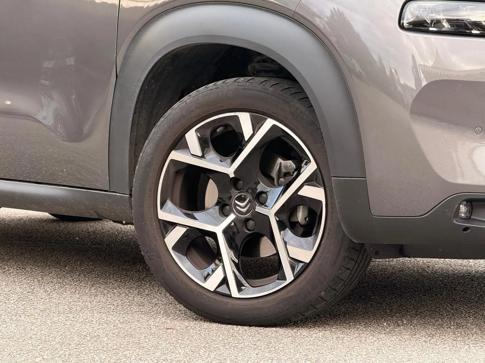 Gros plan sur la roue avant droite du Citroën C3 Aircross gris platinium, mettant en valeur la jante alliage au design moderne.