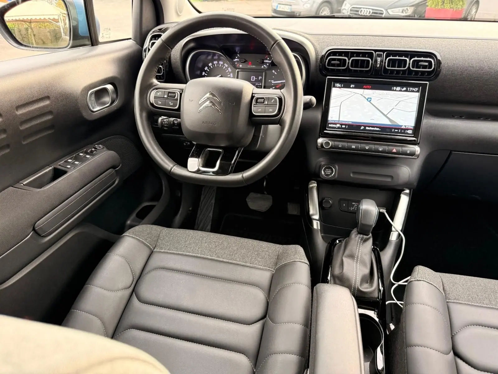 Vue intérieure avant de la Citroën C3 Aircross 2022, tableau de bord noir avec écran tactile et volant multifonction.