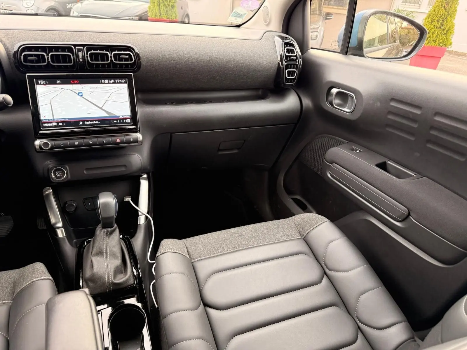 Vue intérieure côté passager du Citroën C3 Aircross 2022, montrant la console centrale avec écran tactile et sellerie grise.