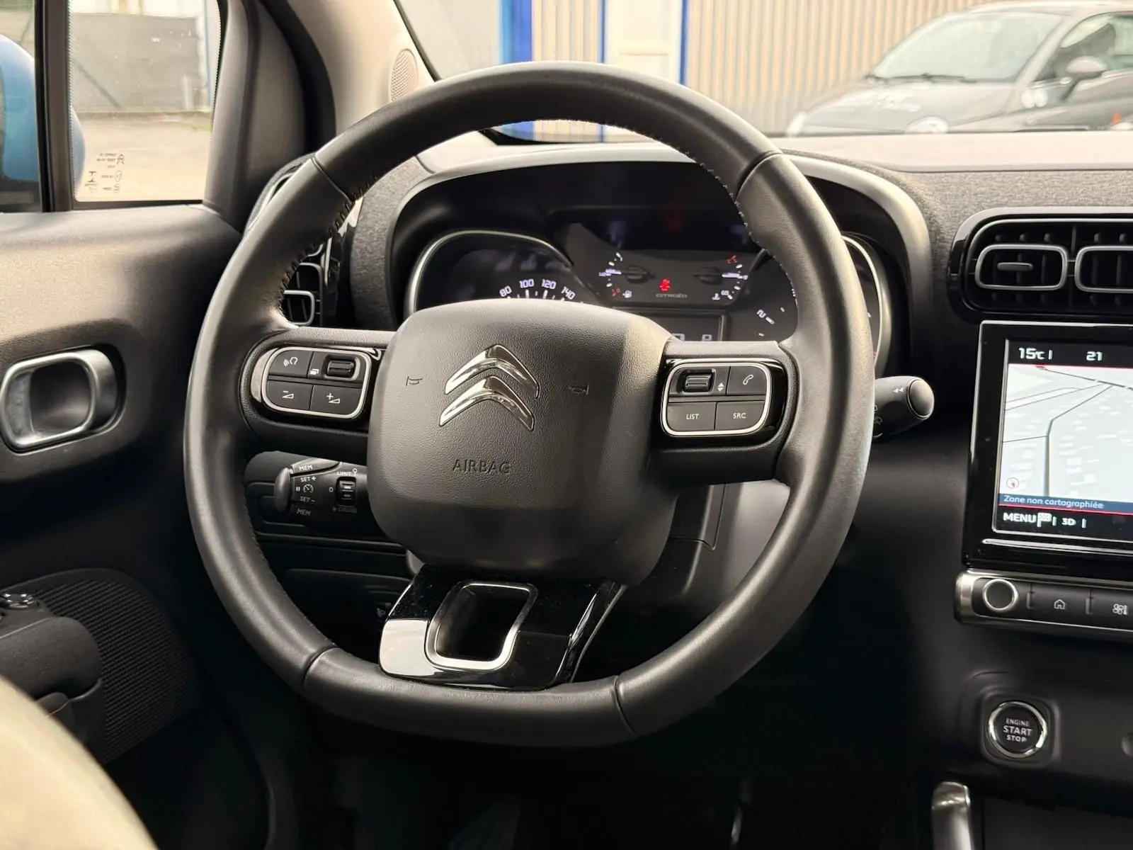 Vue intérieure centrée sur le volant noir d'une Citroën C3 Aircross 2022 avec tableau de bord et écran tactile visible.