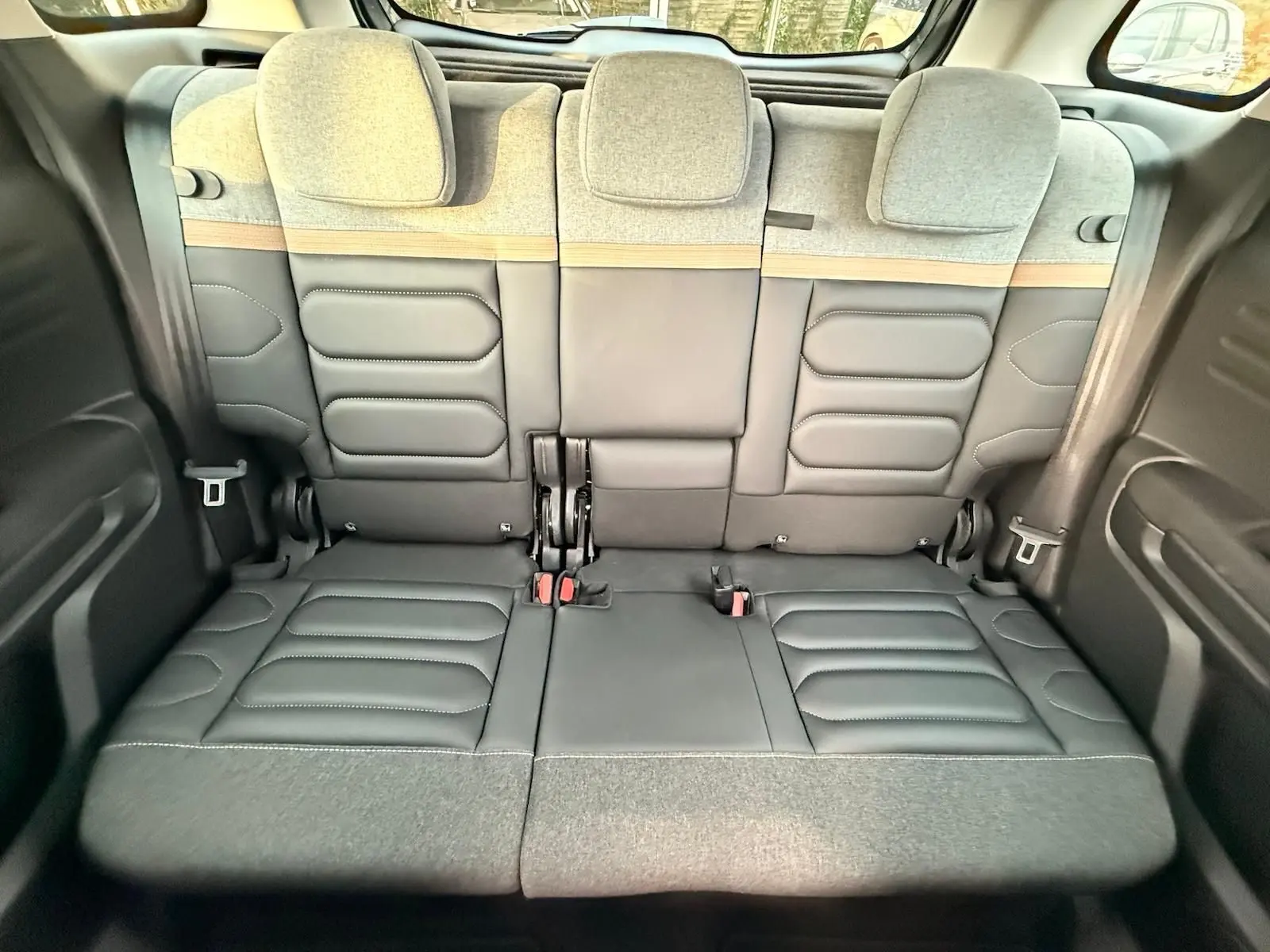 Vue intérieure arrière du Citroën C3 Aircross 2022, sièges arrière gris avec assise cuir et dossier tissu clair bicolore.