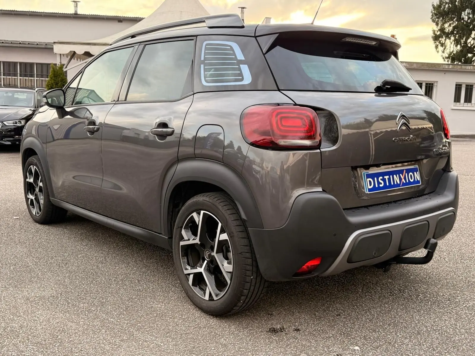 Vue 3/4 arrière droite d’un Citroën C3 Aircross gris platinium avec jantes alliage et toit noir contrasté.
