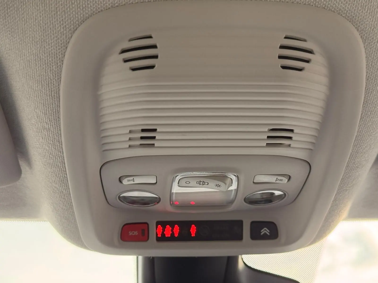 Vue en gros plan du plafonnier intérieur gris clair avec commandes d’éclairage et bouton SOS du Citroën C3 Aircross.