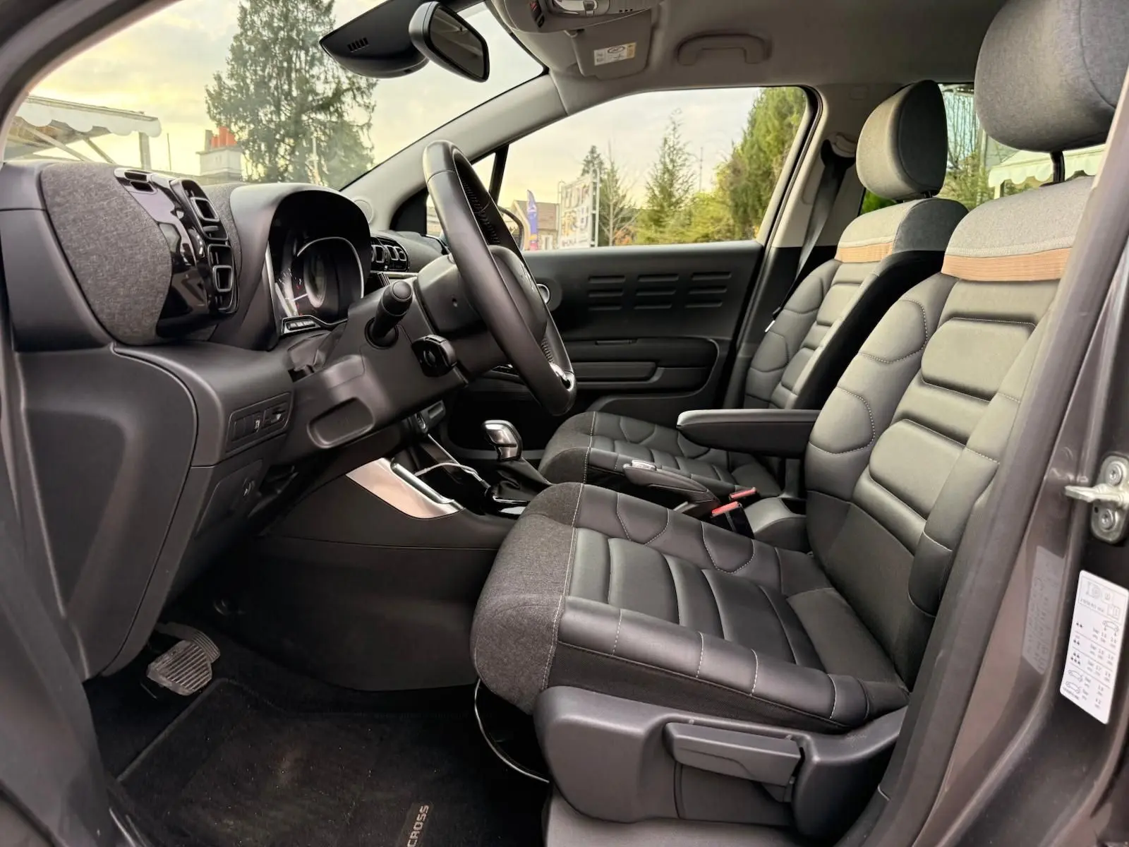 Intérieur avant droit du Citroën C3 Aircross gris platinium 2022, sièges bi-matière avec surpiqûres et tableau de bord moderne.