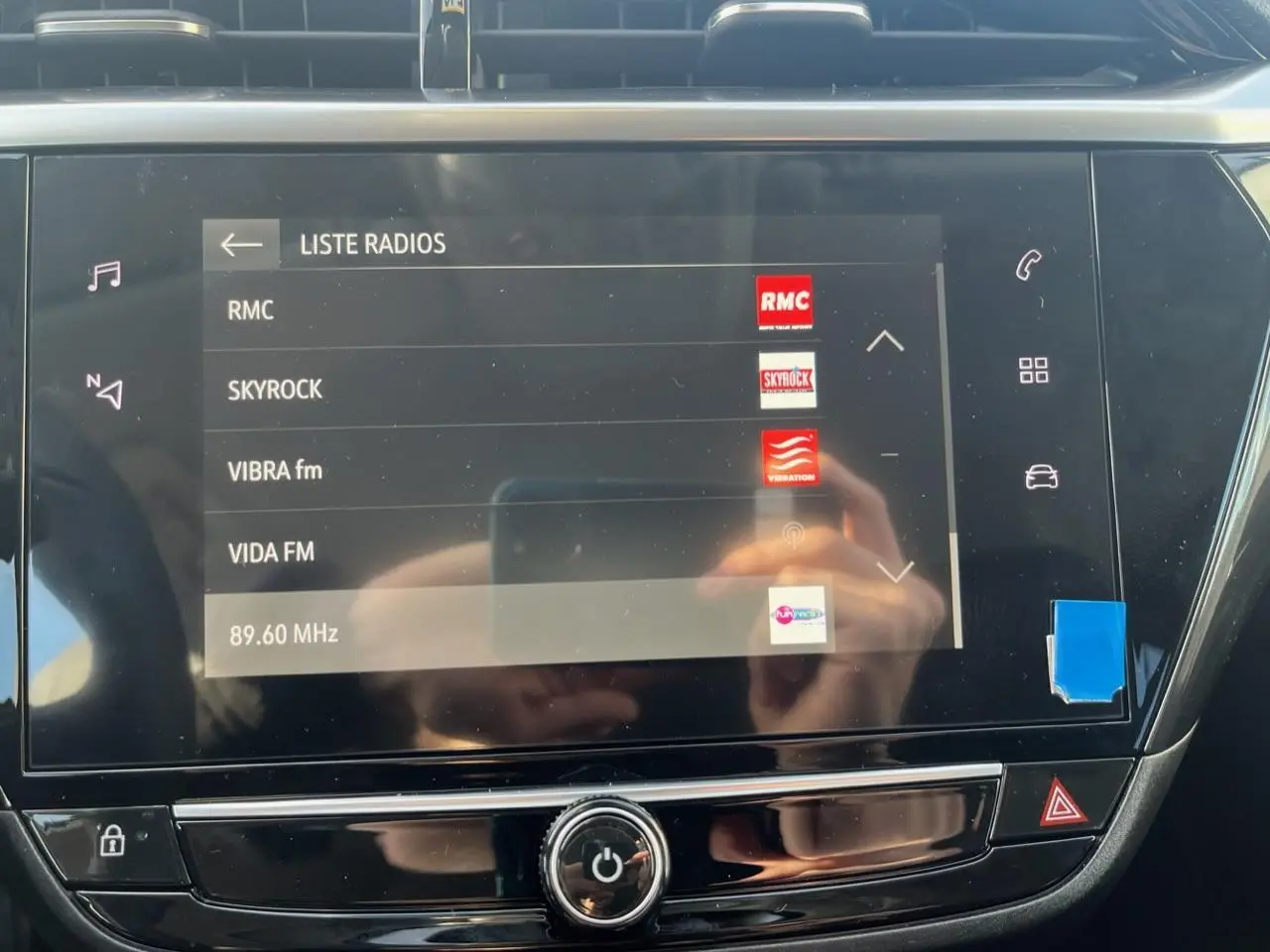 Écran tactile central de l’Opel Corsa 2022 affichant la liste des radios, avec commandes autour en finition noire brillante.