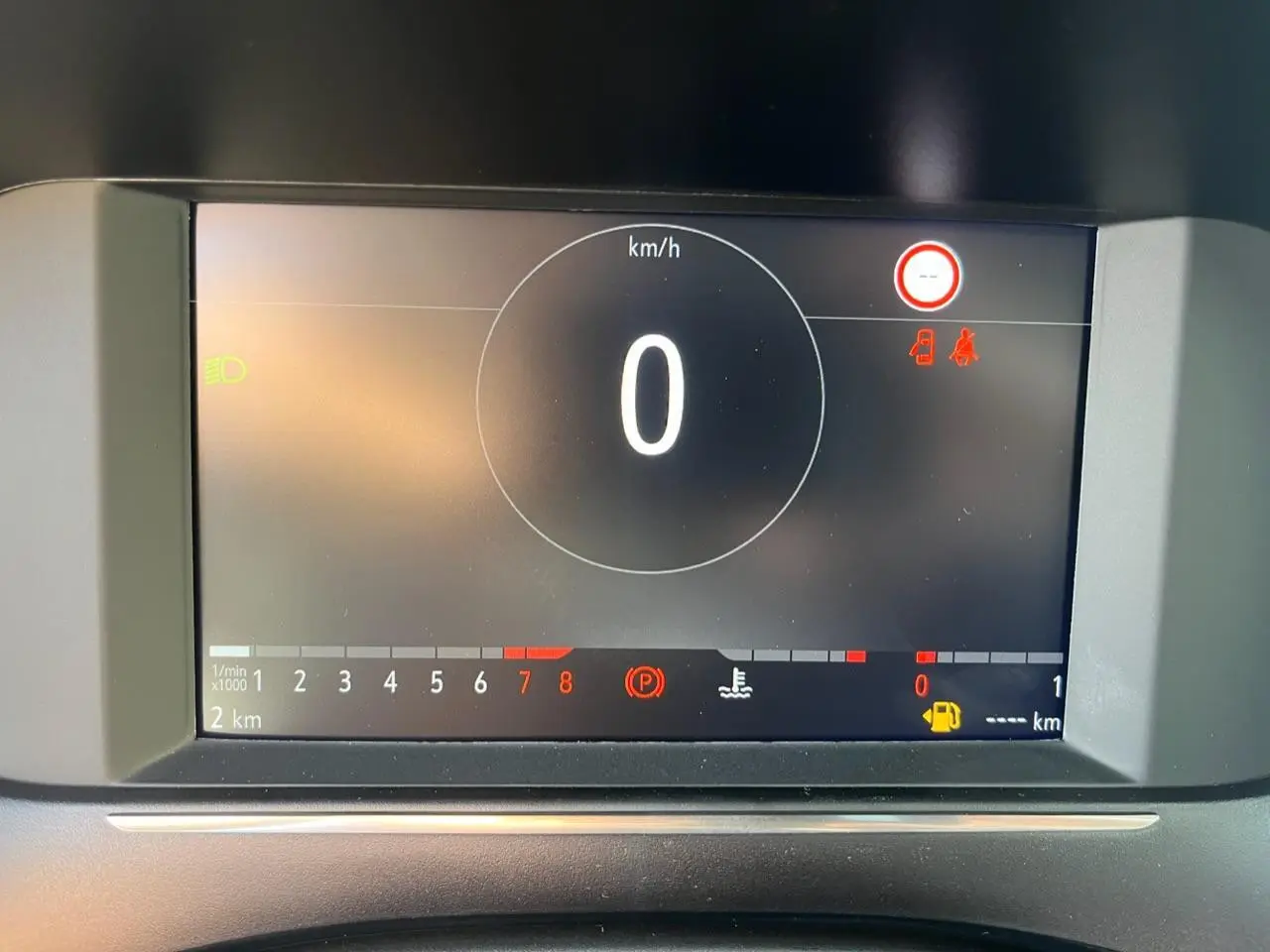 Écran digital du tableau de bord de l’Opel Corsa blanc, affichant vitesse zéro et alertes au frein à main et portières.