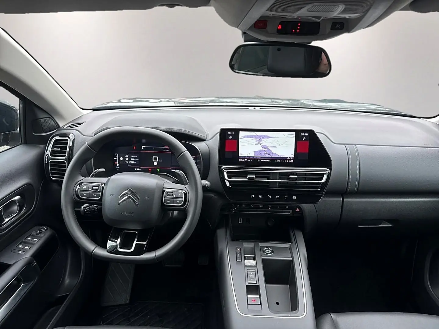Vue intérieure avant du Citroën C5 Aircross 2025, tableau de bord noir avec écran tactile et volant multifonction.