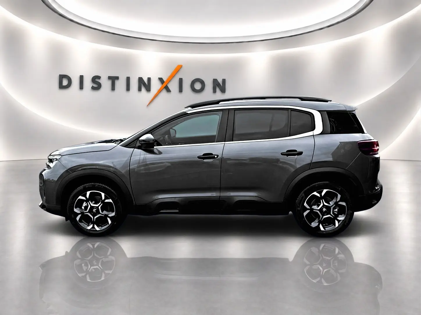 Vue de profil droit du Citroën C5 Aircross gris platinium 2025 avec barres de toit et jantes alu distinctives.