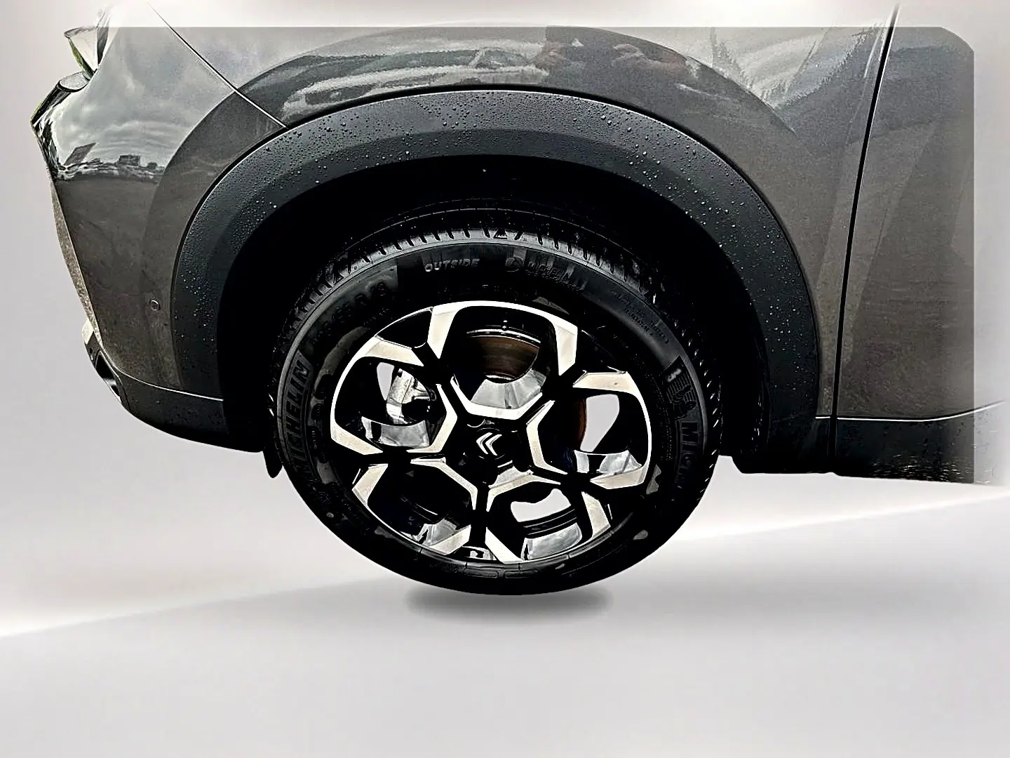 Gros plan sur la roue avant droite du Citroën C5 Aircross gris platinium avec jante alu au design moderne.