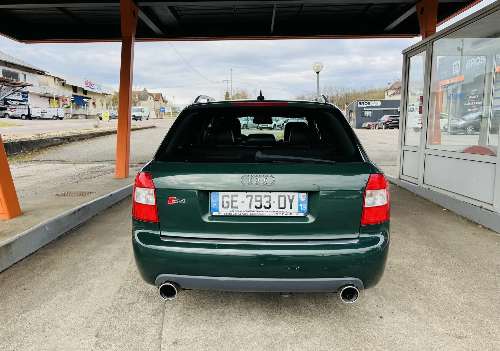 Vue arrière d'une Audi S4 Avant verte 2004 avec double sortie d'échappement et feux rouges distinctifs.