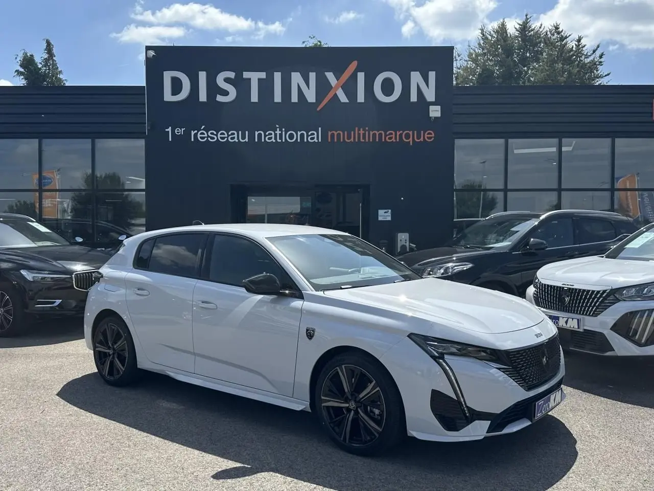 Peugeot 308 blanche vue de profil côté gauche, avec jantes alliage noires et calandre avant noire brillante.