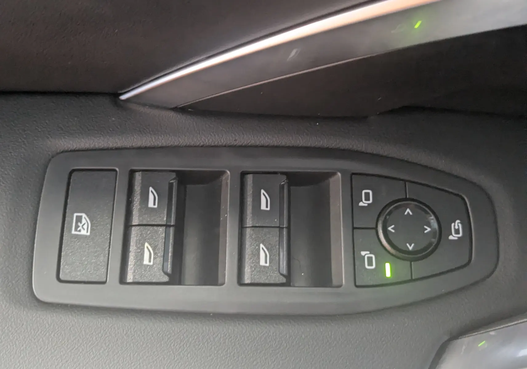 Gros plan sur les commandes des vitres et rétroviseurs côté conducteur du BMW X1 noir 2025, finition M Sport.