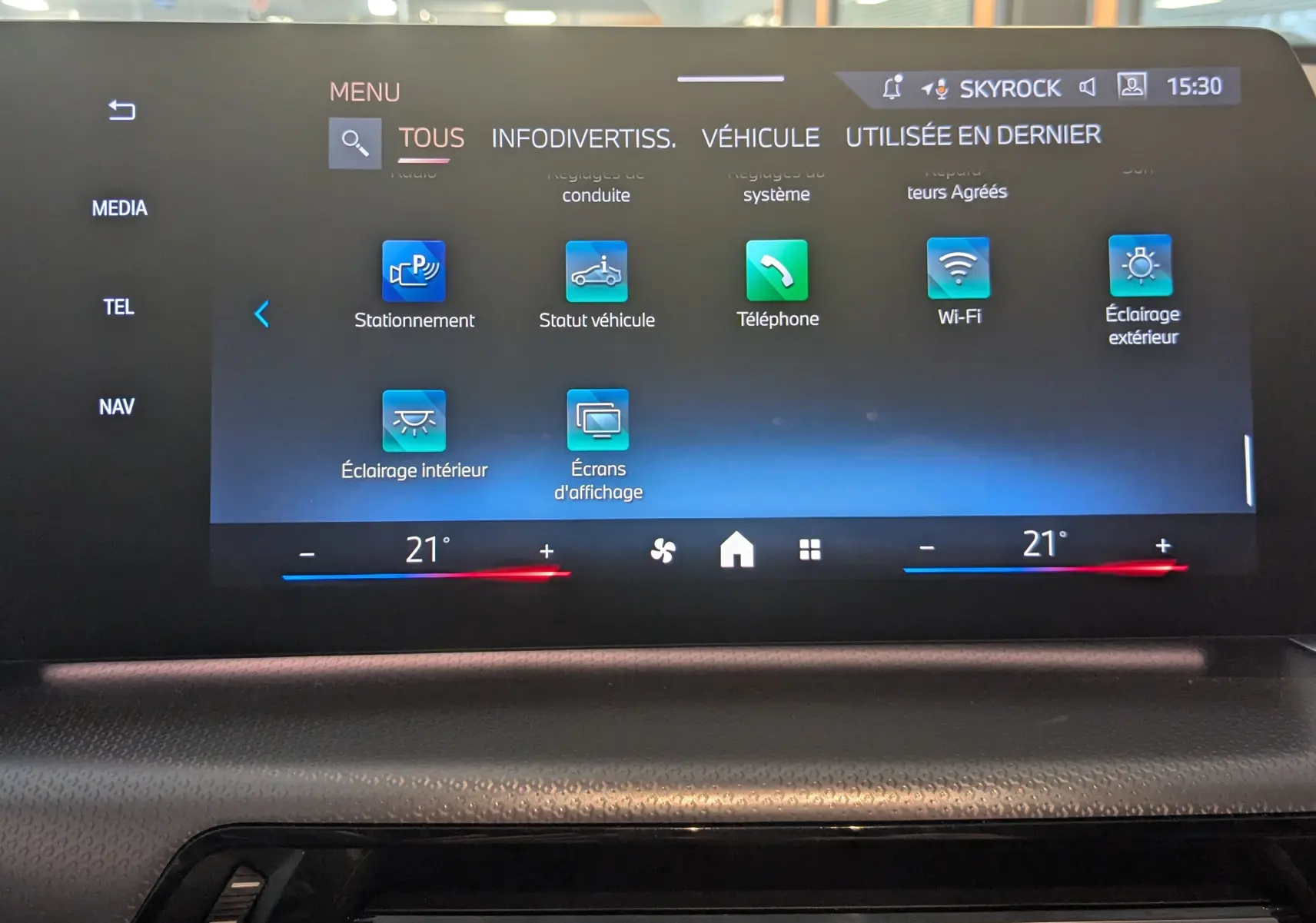 Écran tactile central de la BMW X1 2025 affichant le menu des réglages avec commandes climatisation à 21°C.