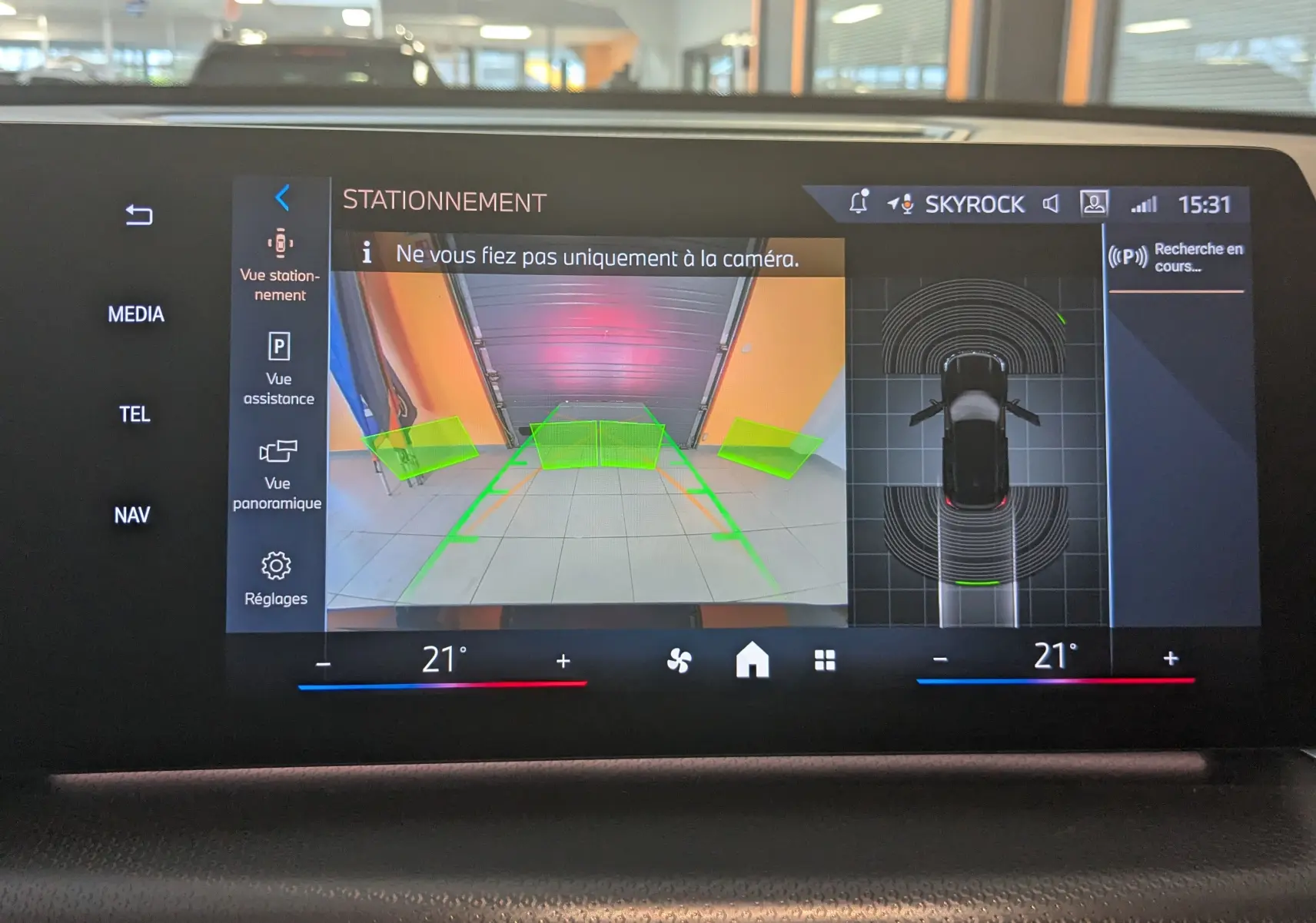 Affichage de la caméra de recul et vue 360° du BMW X1 noir, avec aides au stationnement sur l'écran central.