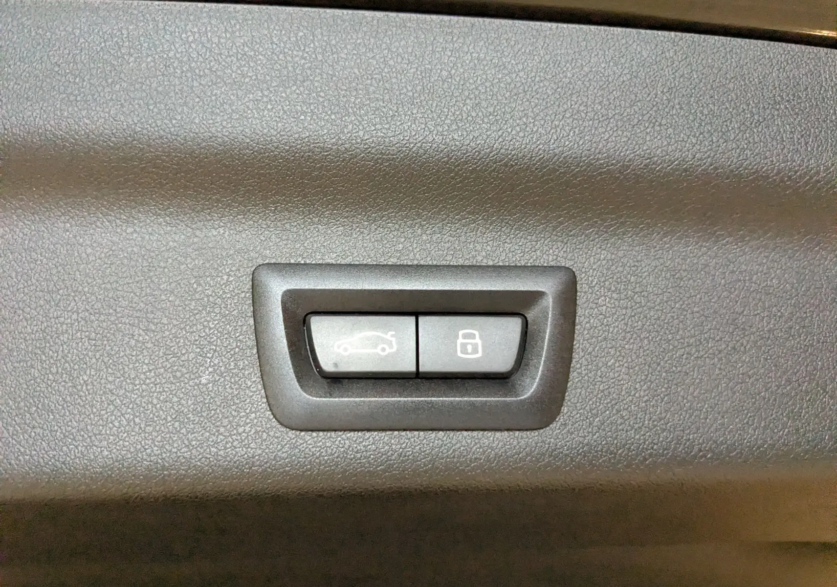 Gros plan sur les boutons d'ouverture et de verrouillage du coffre du BMW X1 noir, version M Sport 2025.