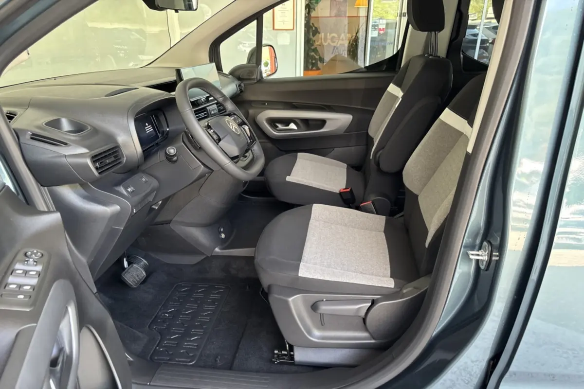 Vue intérieure côté conducteur du Citroën Berlingo Kiama blue 2026, sièges tissu bicolores et tableau de bord noir.