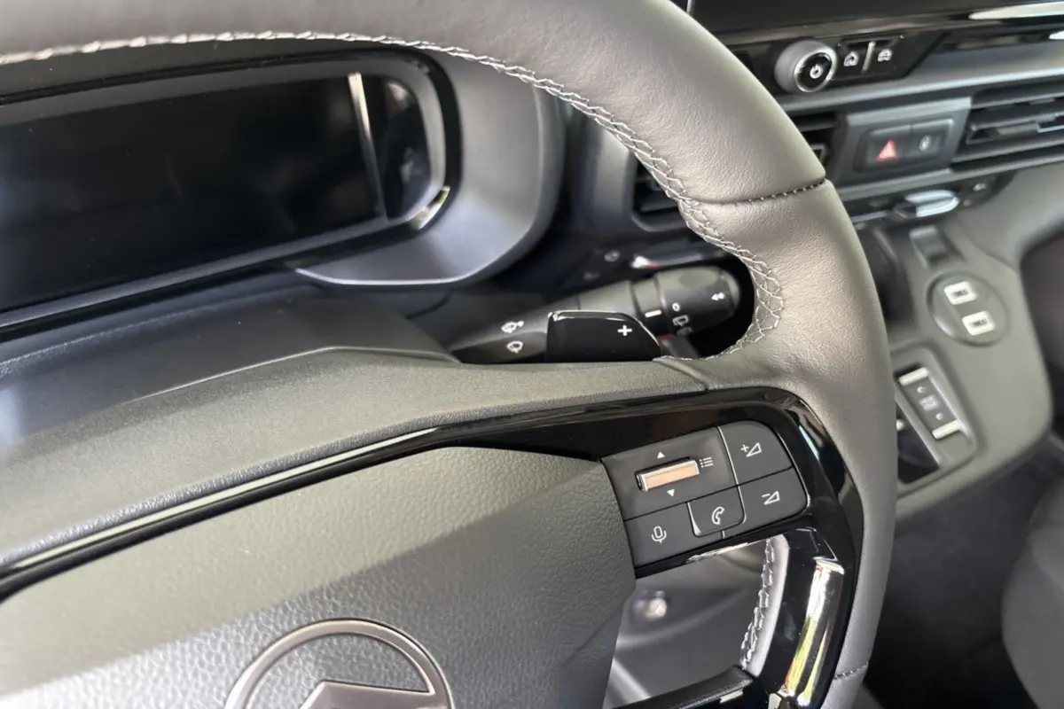 Gros plan sur le volant cuir multifonctions du Citroën Berlingo 2026, mettant en valeur les commandes intégrées.