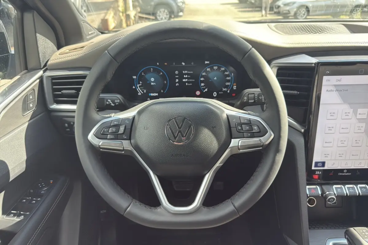 Vue intérieure centrée sur le volant Volkswagen du Amarok Simple Cabine 2025, avec tableau de bord numérique et écran tactile.
