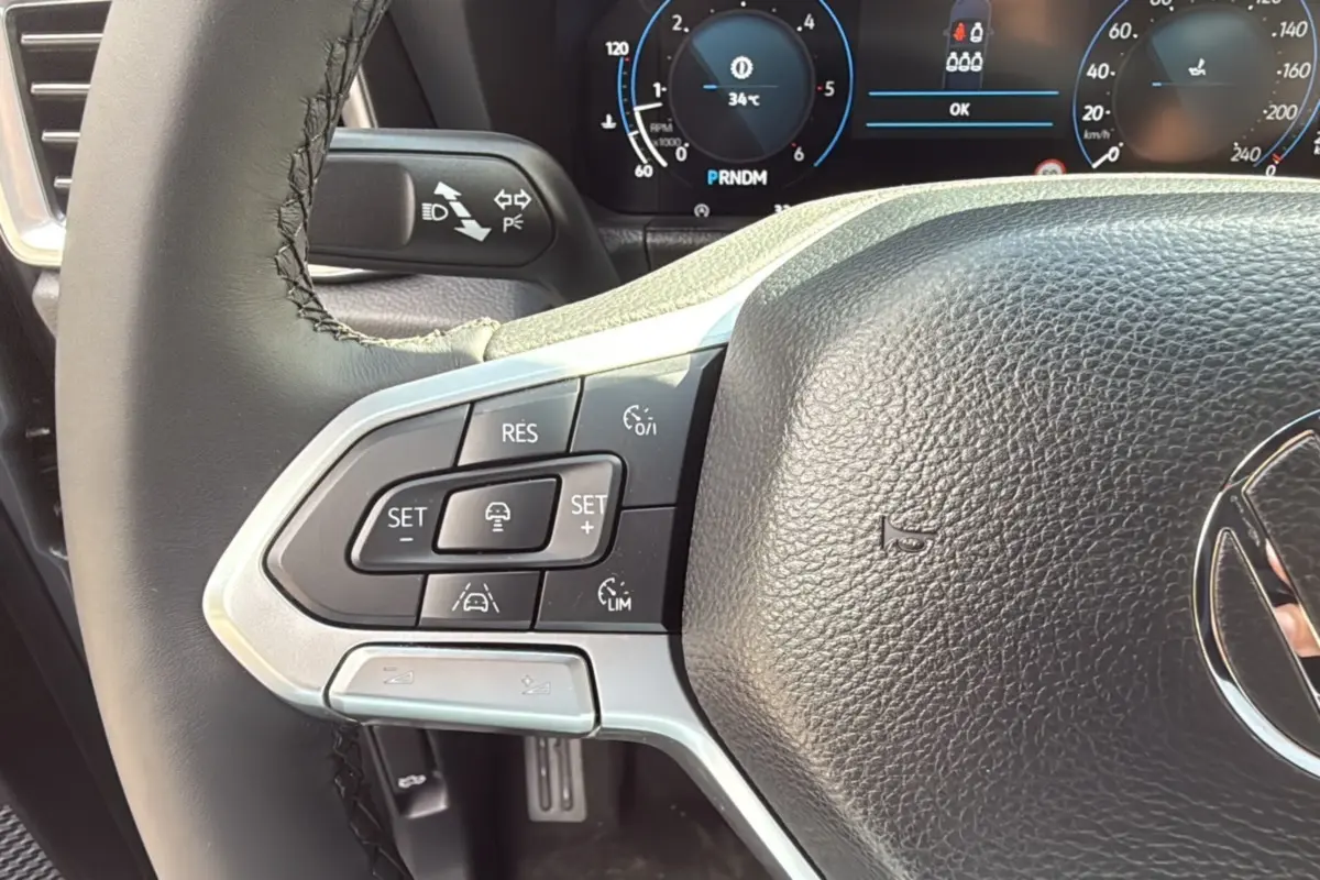 Gros plan sur le volant du Volkswagen Amarok Simple Cabine V6 240 BVA Aventura 2025 avec commandes intégrées et tableau de bord numérique.