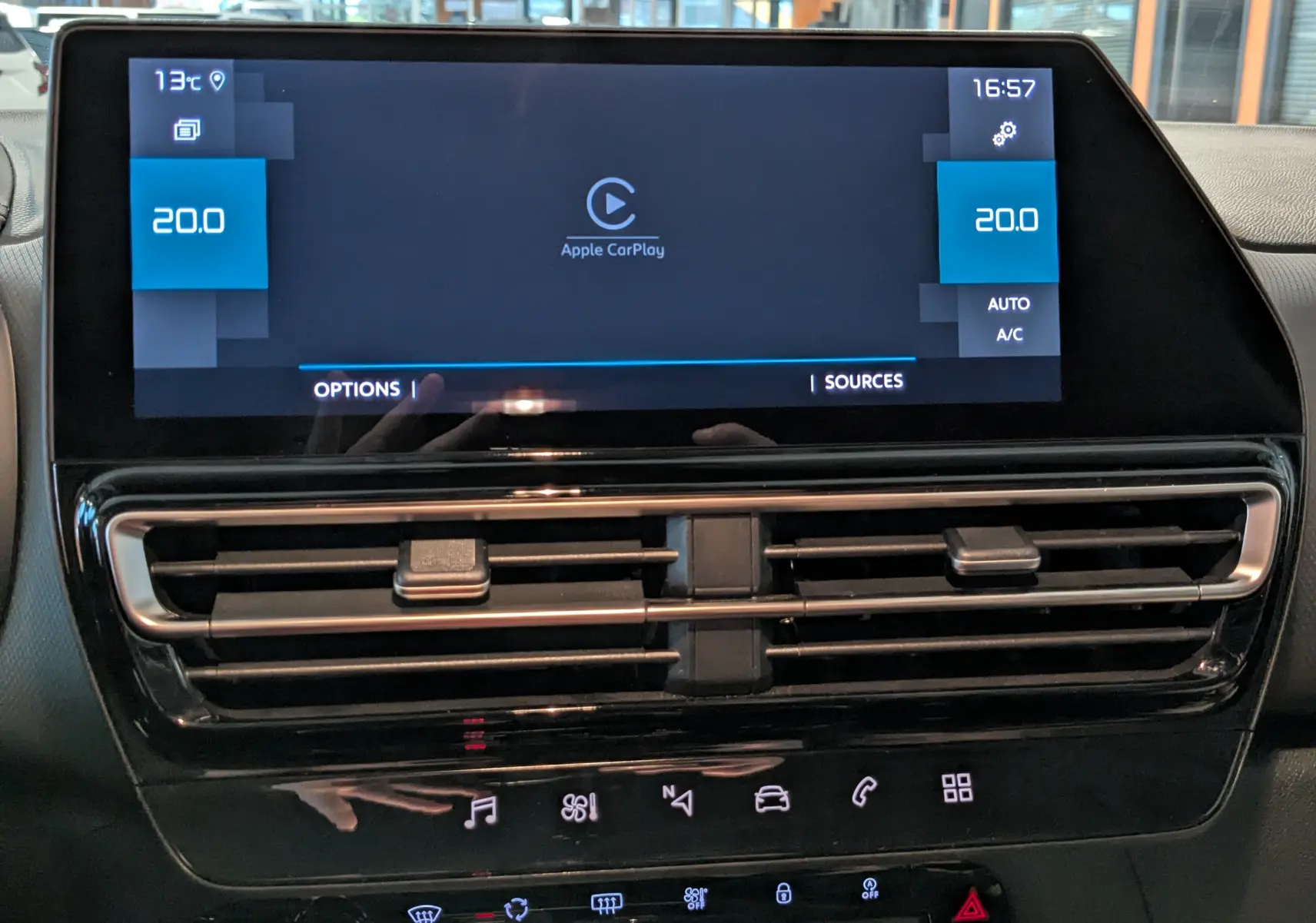 Vue rapprochée de l’écran tactile central et des aérateurs du tableau de bord du Citroën C5 Aircross hybride noir 2025.