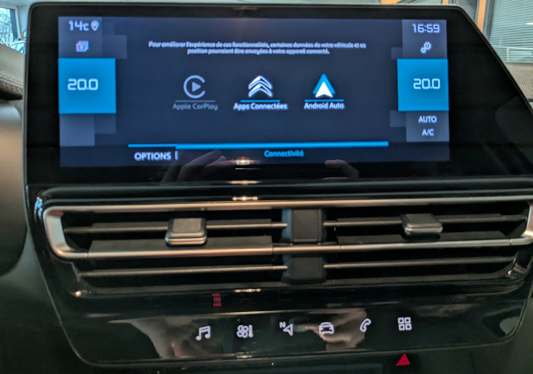 Gros plan sur l’écran tactile central et les aérateurs du tableau de bord du Citroën C5 Aircross hybride noir 2025.