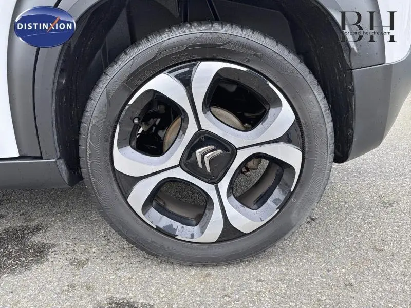 Gros plan sur la roue avant droite de la Citroën C3 Aircross blanche avec jante alliage diamantée noire et argent.