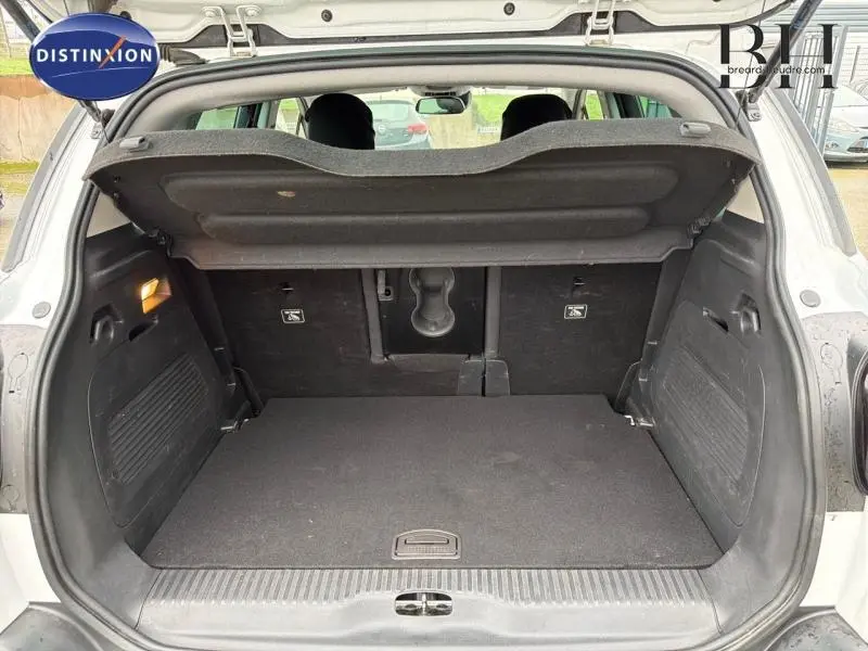 Coffre ouvert vu de l'arrière d'une Citroën C3 Aircross blanche, montrant l'espace de chargement et la tablette cache-bagages.