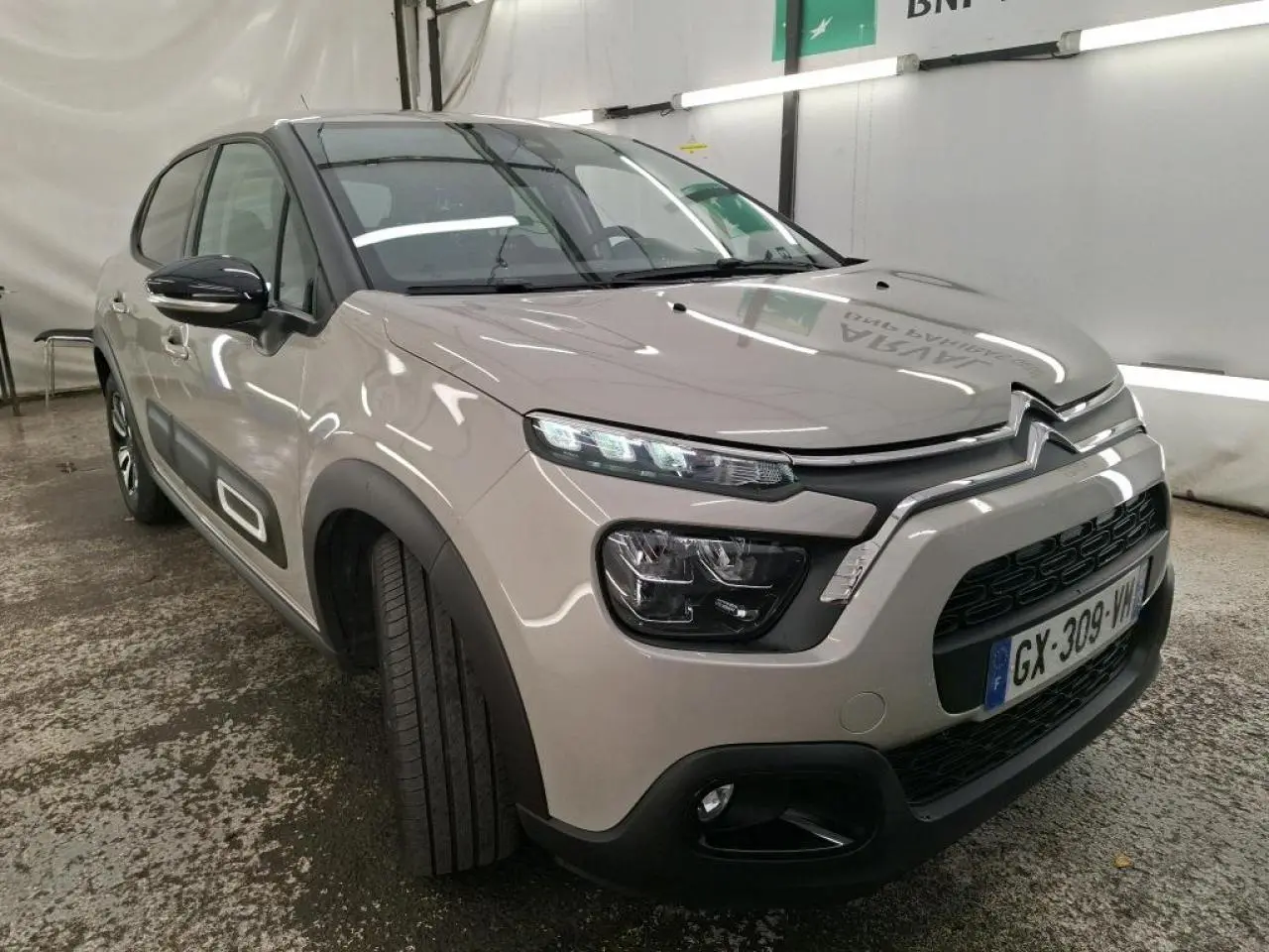 Citroën C3 beige clair vue 3/4 avant droit avec Airbump noir et coques de rétroviseurs noires.