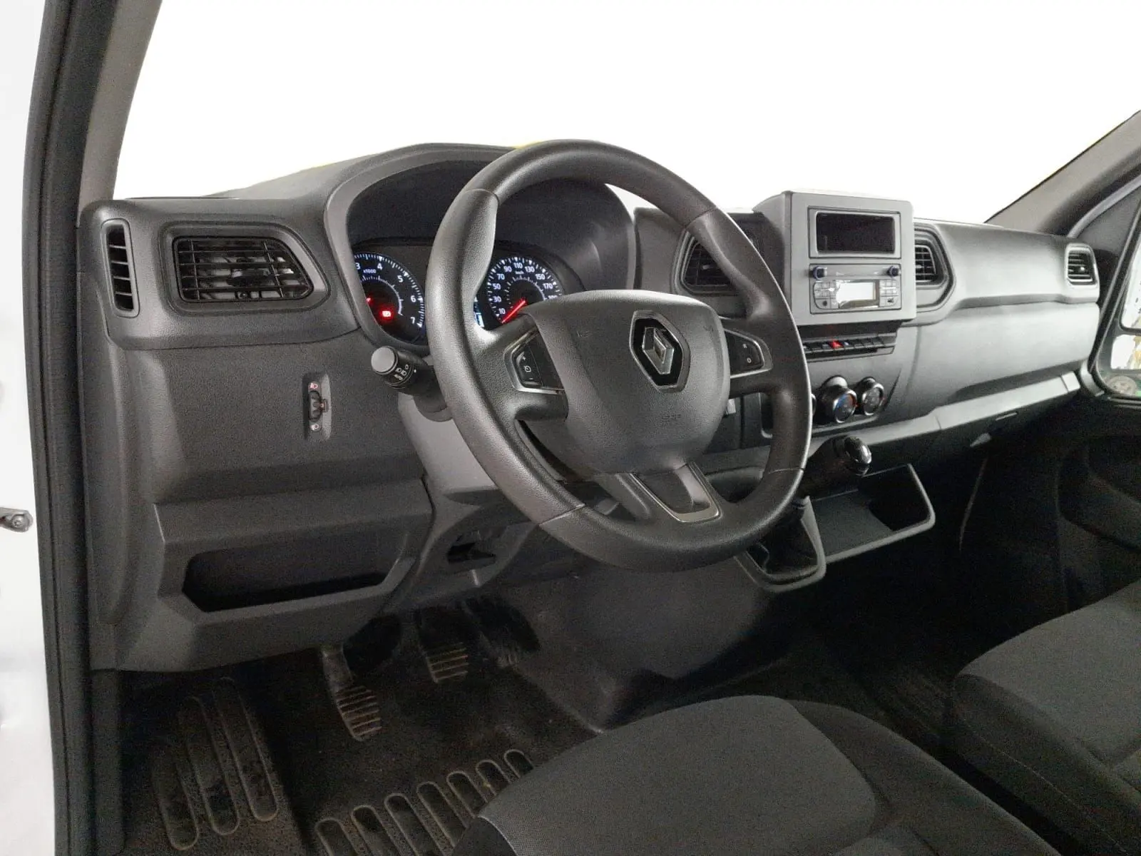 Vue intérieure côté conducteur du Renault Master 2024, tableau de bord noir avec volant multifonction et levier de vitesses manuel.