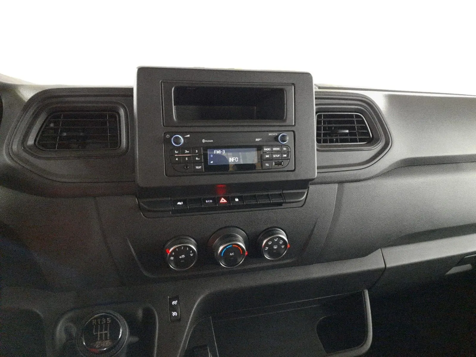 Vue rapprochée du tableau de bord noir du Renault Master 2024, avec commandes de climatisation et radio intégrée.