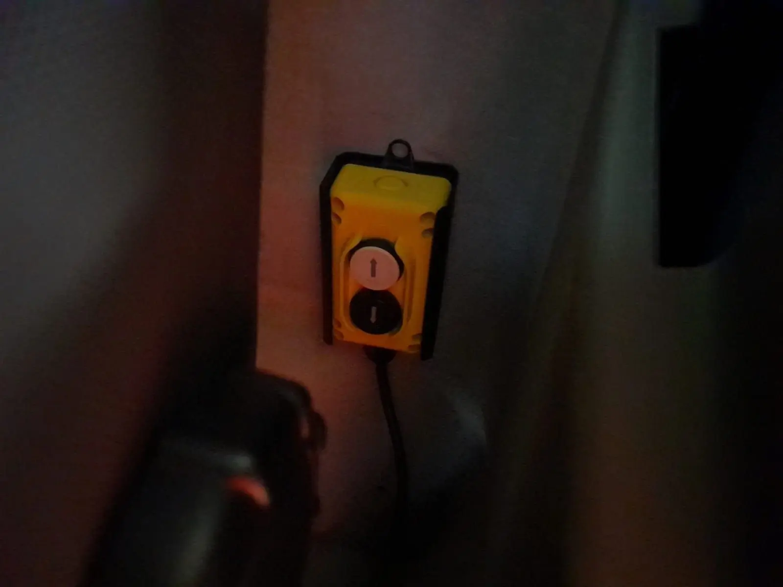 Vue intérieure sombre du boîtier de commande jaune fixé dans la cabine du Renault Master blanc 2024 version benne.