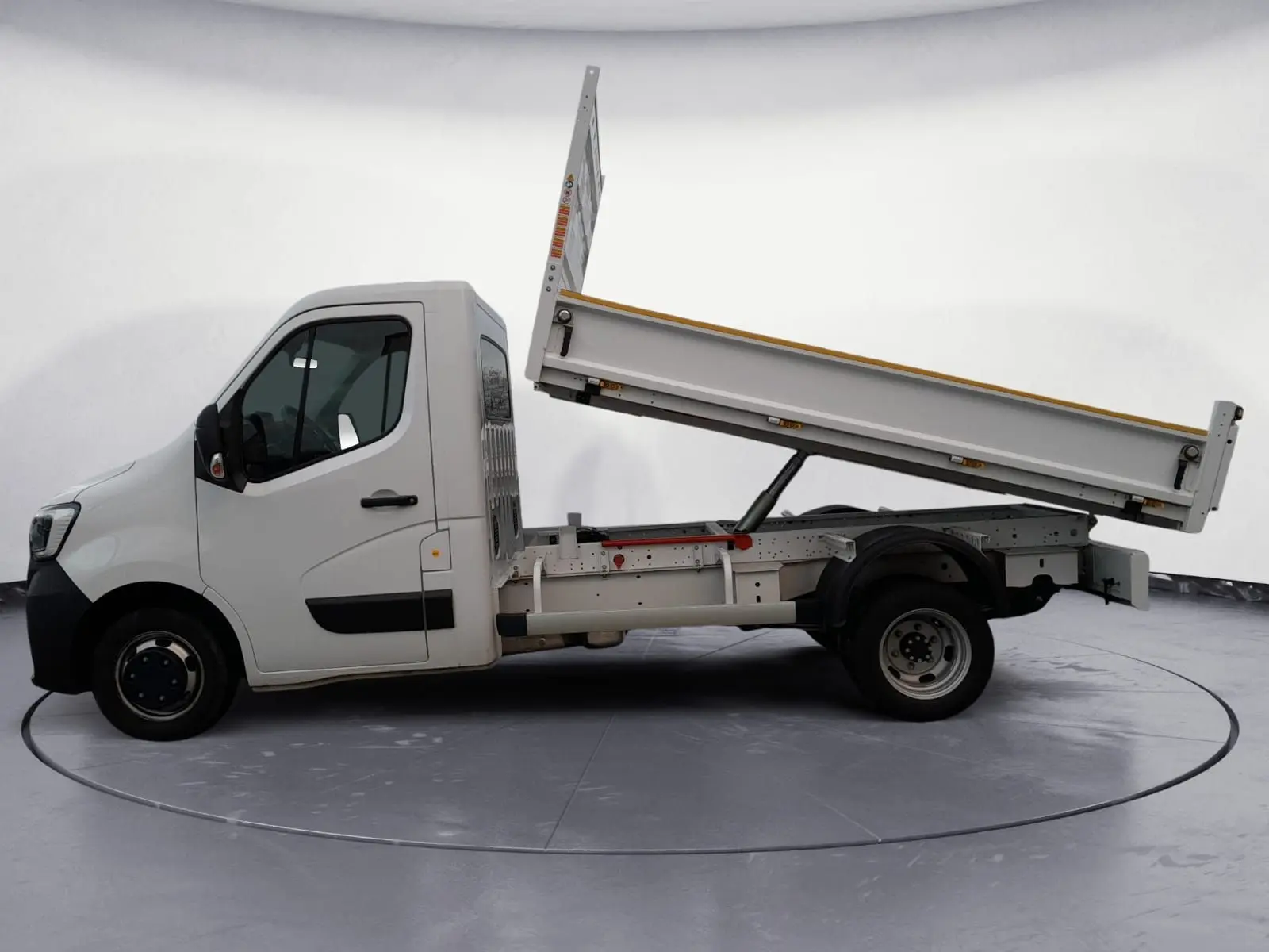 Renault Master blanc vue de profil gauche avec benne arrière relevée sur fond neutre.