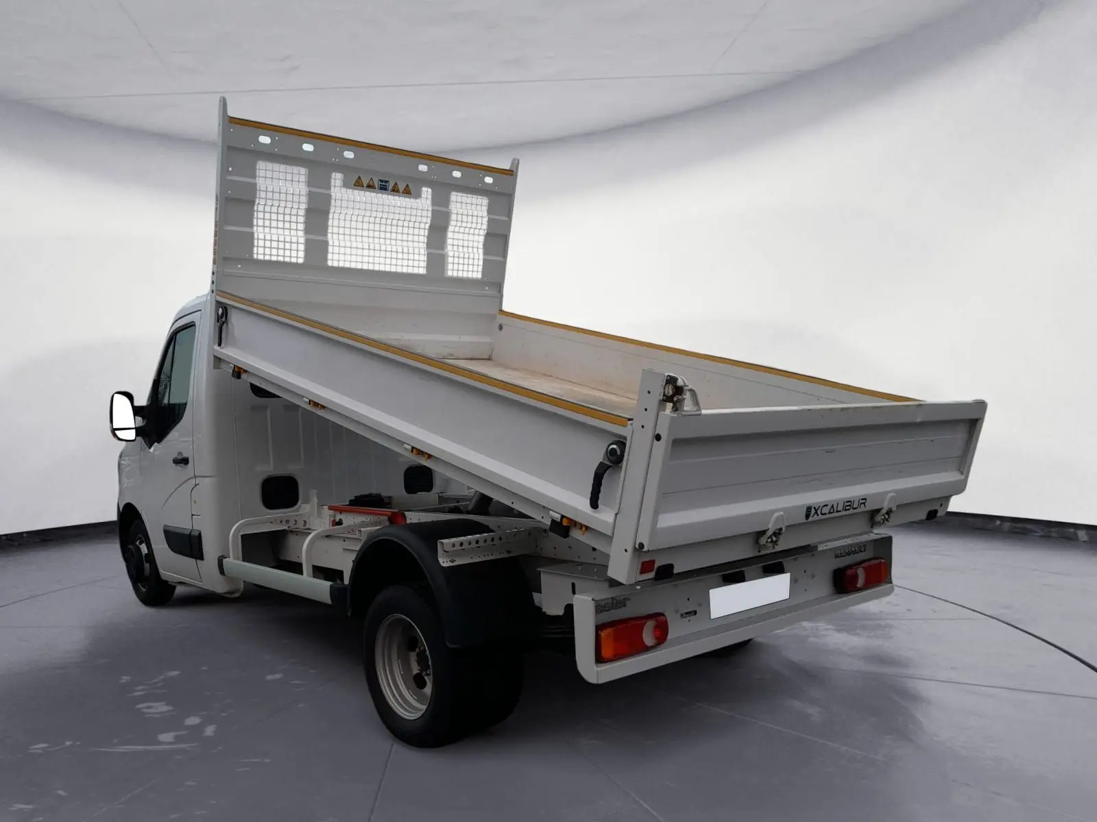 Vue 3/4 arrière droite du Renault Master blanc 2024 avec benne basculante relevée et cabine simple.