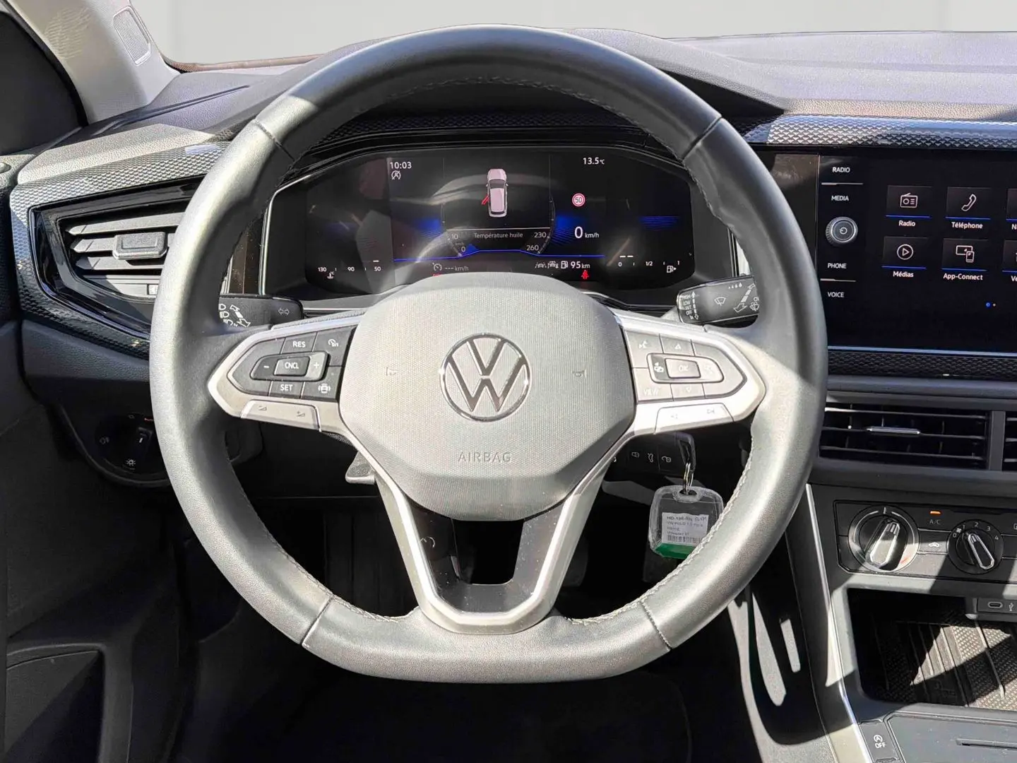 Vue frontale du volant cuir noir et du tableau de bord digital de la Volkswagen Polo 2025 avec écran tactile et commandes intégrées.