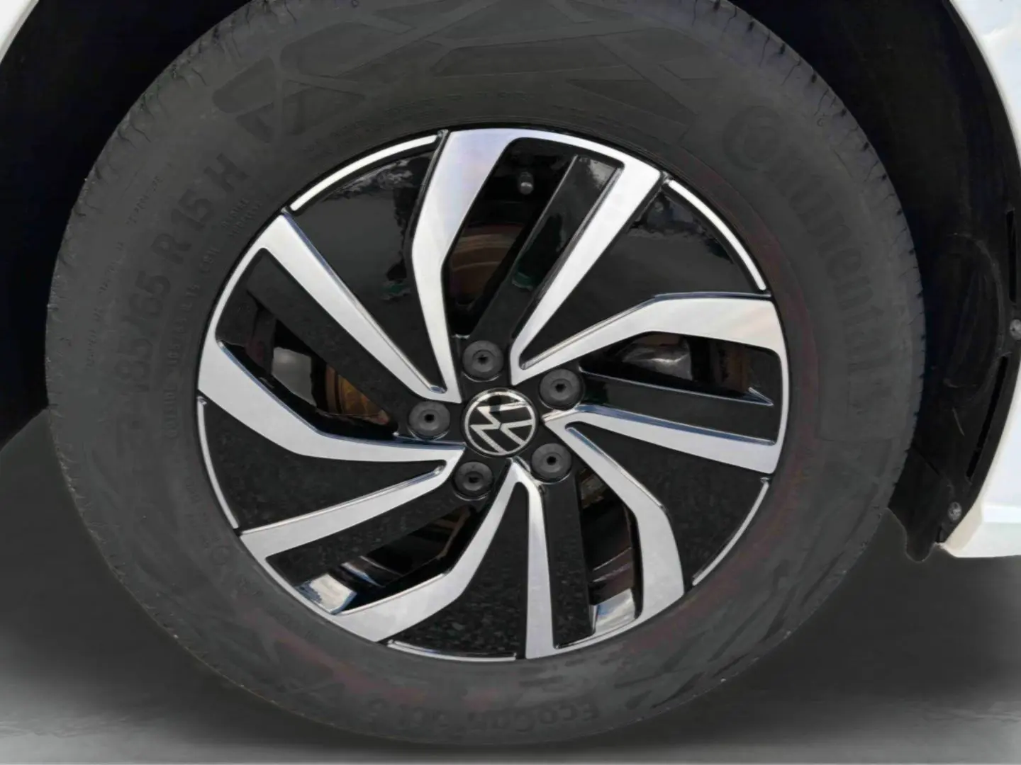 Gros plan sur la jante alliage noir et argent de 15 pouces d'une Volkswagen Polo blanche, avec pneu Continental visible.