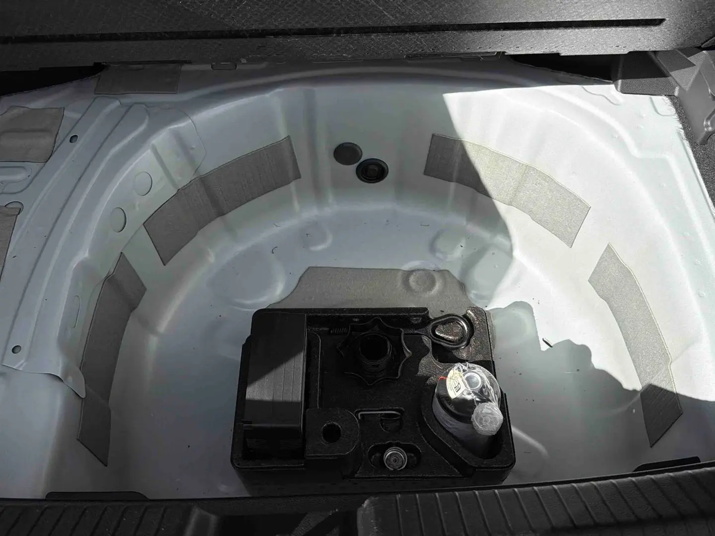 Coffre ouvert montrant la roue de secours blanche et un kit d’outils noir au centre du Volkswagen Polo 2025.