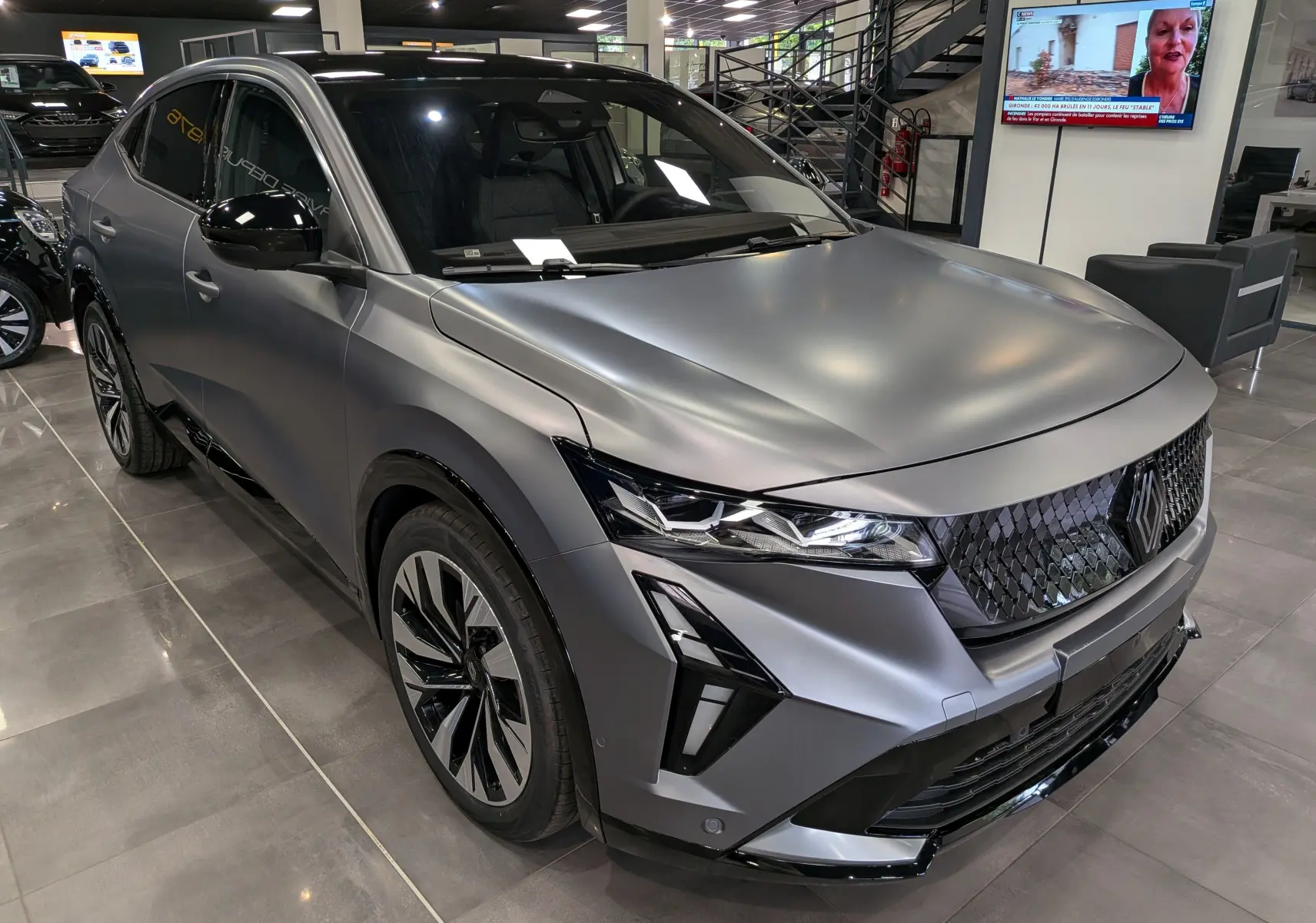 Vue 3/4 avant droite du Renault Rafale gris schiste satin avec calandre noire texturée et phares LED distinctifs.