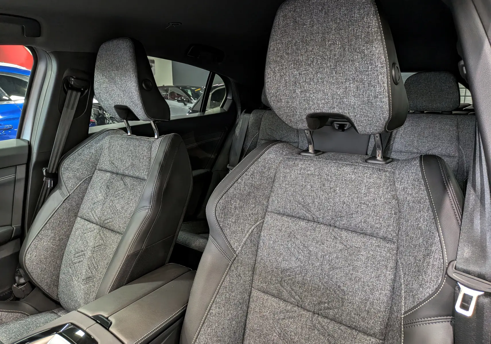 Vue intérieure rapprochée des sièges avant en tissu gris et cuir noir du Renault Rafale E-Tech 2026.